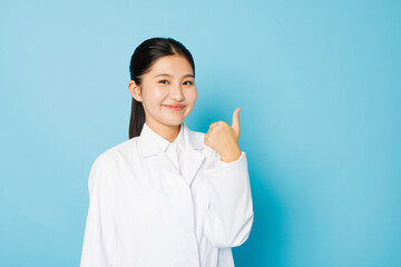 カメラに向かってポーズをとる白衣を着たアジアの 10 代の少女
