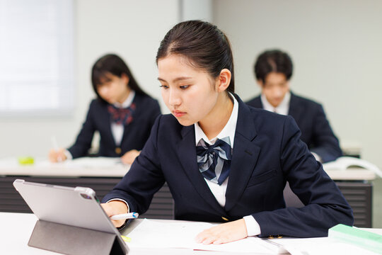 携帯電話を使って勉強するアジアの 10 代の少女