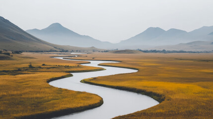 Serene landscape: A winding river meanders through a golden field, set against a backdrop of misty mountains.  Peaceful and picturesque.