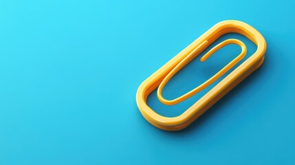 Obraz premium Yellow paperclip on blue background; office supplies (1)