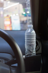 Water bottle placed on the car. Cup holder for water bottle in black car interior.