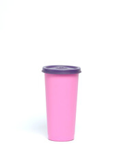 Plastic cup for warm water in pink isolated on white background.Copy space for text.For graphic design or banner background.Plain plastic cup for mockup design