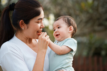 Happy family outdoors. Mother hugs her child outside. Mother holds her toddler. Mother hugs her baby with love and care.