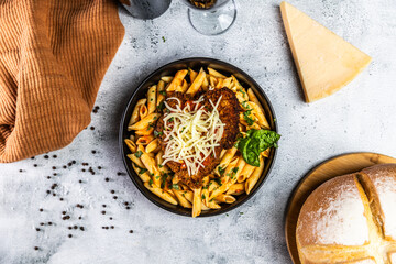 Crispy breaded chicken served over penne pasta tossed in a spicy arrabbiata sauce, topped with fresh basil and shredded mozzarella cheese.