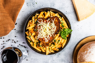 Crispy breaded chicken served over penne pasta tossed in a spicy arrabbiata sauce, topped with fresh basil and shredded mozzarella cheese.