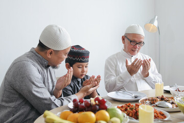 Father Teaching Son To Praying Dua Before Eating Special Dish On Eid Al Fitr Moment 