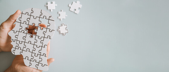 Hands holding brain with puzzle paper cutout, autism, dementia, Epilepsy and Alzheimer awareness,...