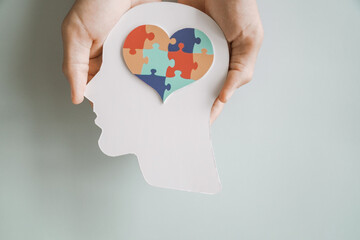 Hands holding jigsaw puzzle heart shape in brain Autism awareness, neurodiversity concept, World...