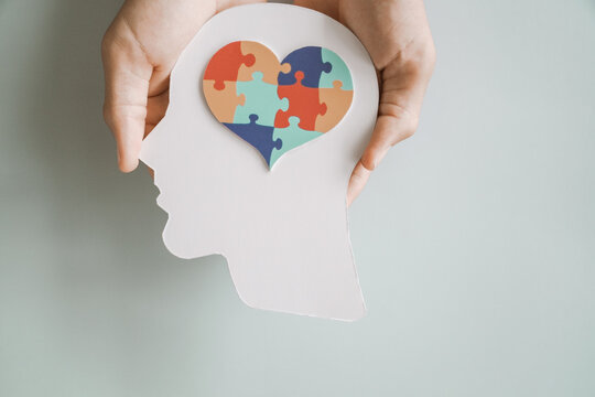 Hands holding jigsaw puzzle heart shape in brain Autism awareness, neurodiversity concept, World Autism Awareness Day.