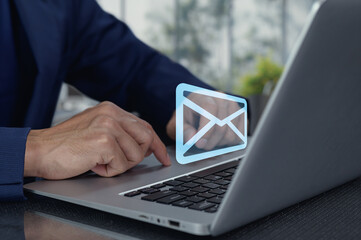 Hands Typing on Laptop with Email Icon in Modern Workspace