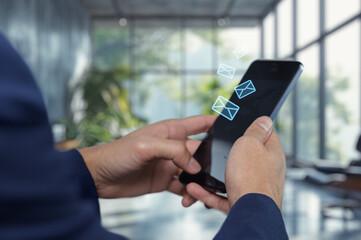 Person Using Smartphone to Check Emails in Modern Office Setting