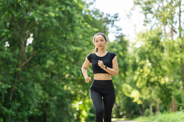 A woman in sportswear running in the park, enjoying fresh air, engaging in outdoor activities to maintain a healthy lifestyle, boosting cardiovascular health, and feeling happy and energetic