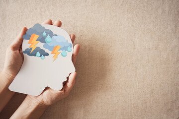 Hands holding paper brain thunder storm, mental health, depression, panic attack concept