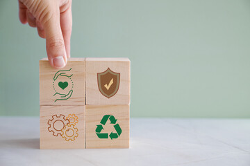 Hands holding wooden blocks with HSE and health, safety and environment icons, for preventing...