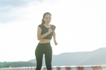 A woman in sportswear running in the park, enjoying fresh air, engaging in outdoor activities to maintain a healthy lifestyle, boosting cardiovascular health, and feeling happy and energetic