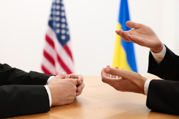 Diplomats negotiating during meeting at wooden table indoors, closeup