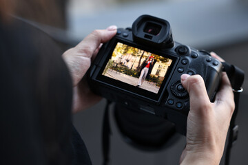 Professional photographer with digital camera outdoors, closeup