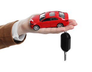 Woman with car model and key on white background, closeup. Buying auto