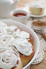 Delicious frosted cinnamon rolls on table, closeup