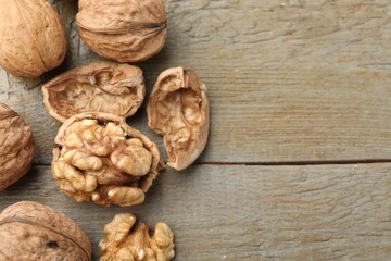 Fresh walnuts on wooden table, flat lay. Space for text