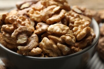 Fresh walnuts in bowl on table, closeup