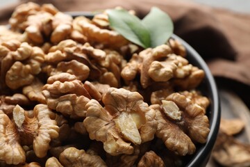 Fresh ripe walnuts in bowl on table, closeup