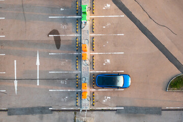 Fototapeta premium Top view of blue electric car receives a charge from a modern parking lot power point