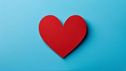 a single red paper heart on a blue background depicting love and warmth