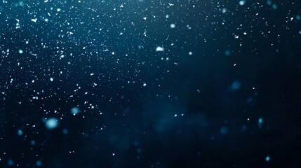 Obraz premium White snowflakes floating sparsely on a rich dark blue background, creating a calm and serene winter night feel, leaving ample blank space at the top for advertisements or logos