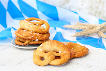 Plate with soft pretzels and flag of Bavaria on white background