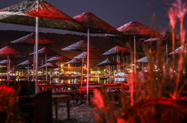 Romantic beach in red lights with calm water in a beautiful bay of the sea at night