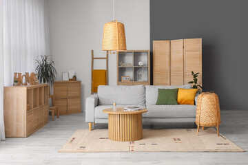 Interior of cozy living room with grey sofa, wooden table and lamps