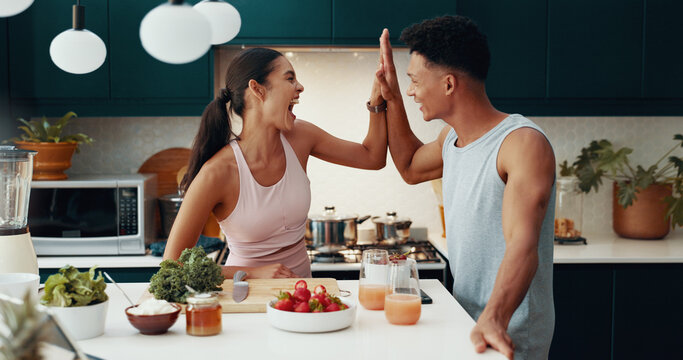 Kitchen, cooking and happy couple high five for success, fitness goal or food for nutrition. Woman, man and celebration in home together for achievement, healthy diet or excited for wellness target