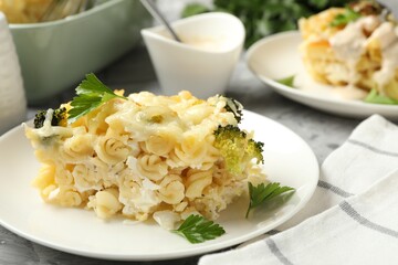 Tasty pasta casserole with cheese and broccoli served on grey table, closeup