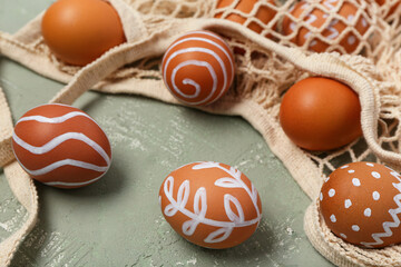 String bag with painted Easter eggs on grey background