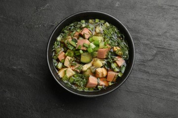 Delicious okroshka soup with kvass on black table, top view