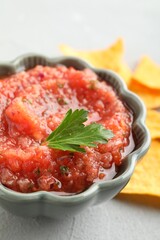 Delicious spicy salsa sauce in bowl on grey textured table, closeup