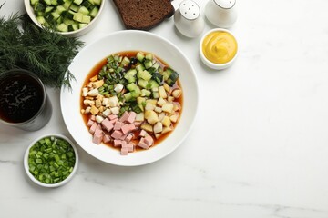 Tasty okroshka soup with kvass and ingredients on white marble table, flat lay. Space for text