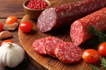Different smoked sausages, cherry tomatoes and spices on table, closeup