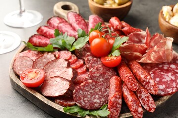 Different smoked sausages slices served on grey table, closeup