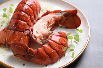 Delicious tails of boiled lobsters served on grey table, closeup