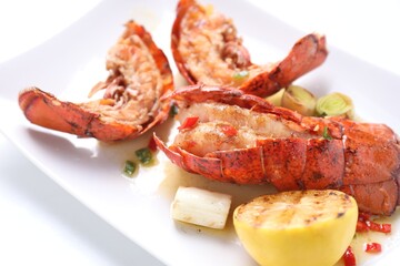 Delicious lobster tails with lemon and green onion on white table, closeup
