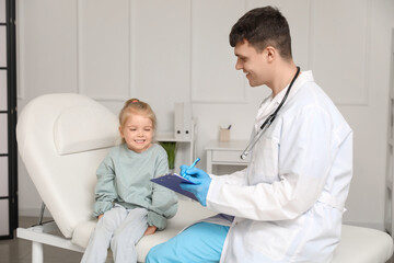 Obraz premium Male pediatrician with clipboard and little girl in clinic