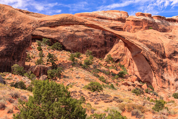 A desert landscape with a large archway in the middle