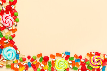 Candies, jelly bears and lollipops on beige background