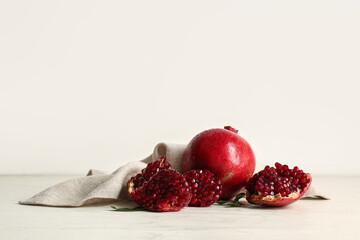 Fresh ripe pomegranates and leaves on white wooden table