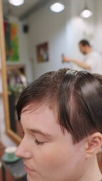 Hairdresser combing wet hair in slow motion