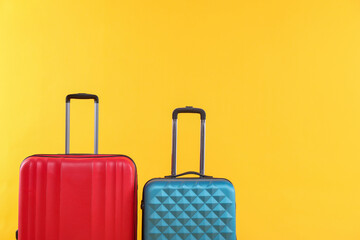 Travel abroad. Packed suitcases on yellow background, space for text