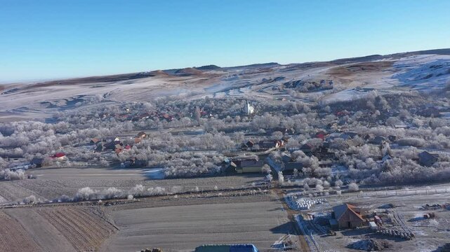 Aerial view of a misty countryside village, nature covered with hoarfrost