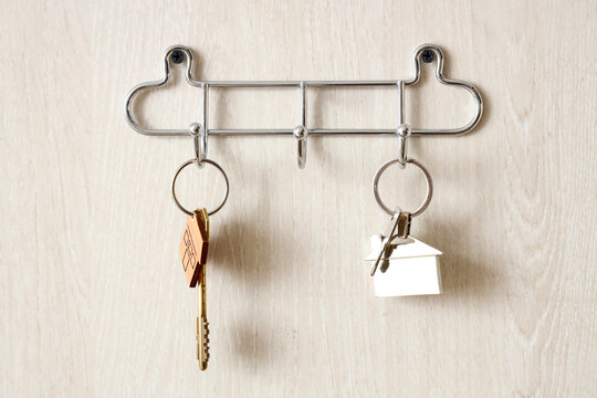 Hooks with keys hanging on white door, closeup